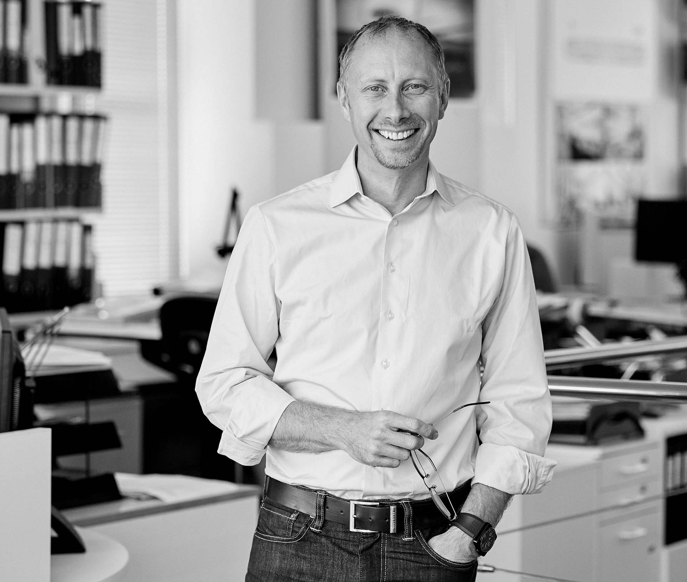 Jim Dixon black and white image in an office smiling