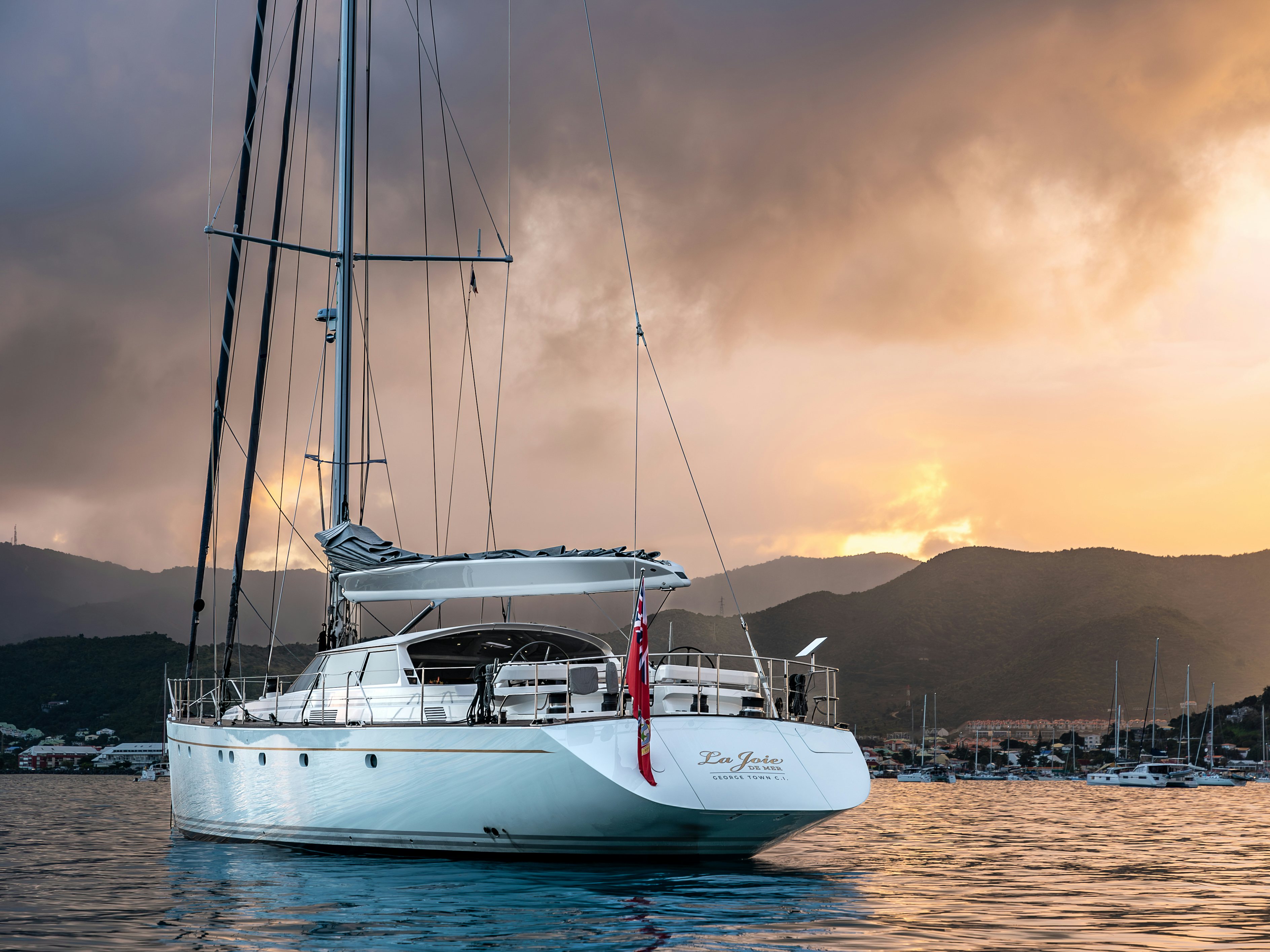 Joie de la mer in a bay anchored with clouds at sunset