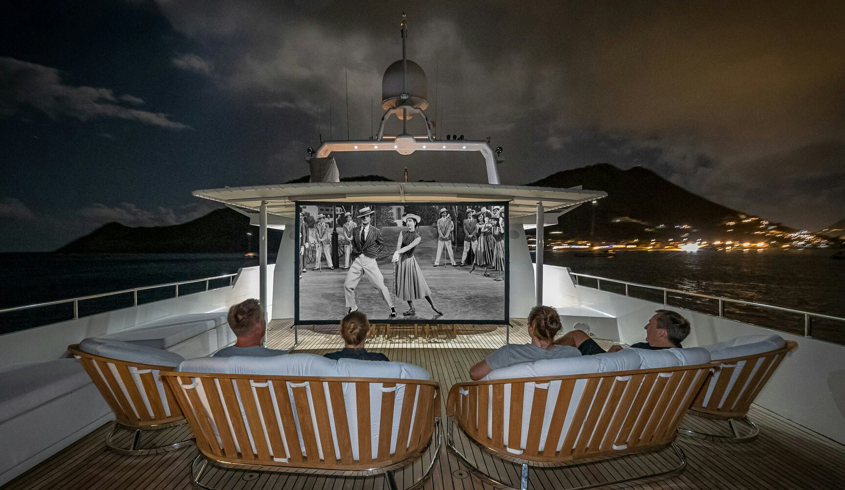 People watching a black and white movie on a projector screen on charter yacht LIONSHARE