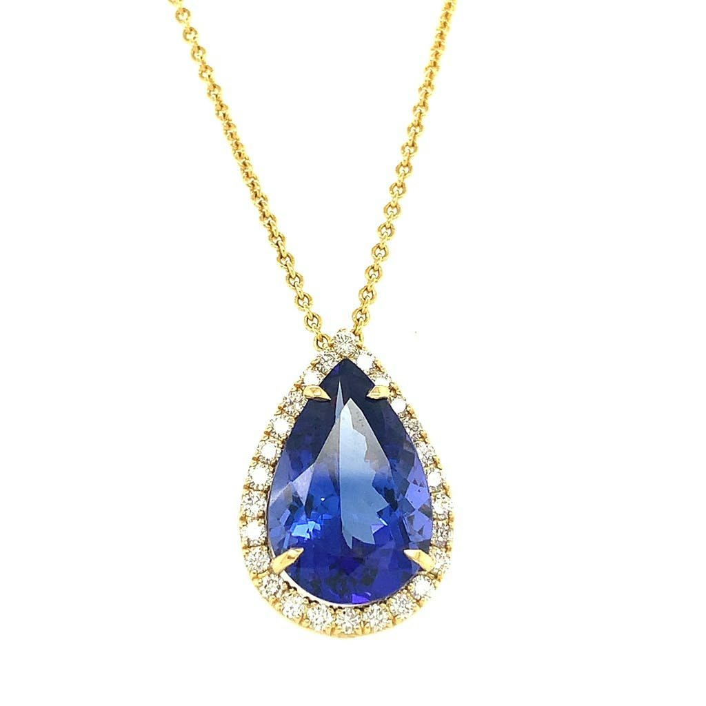 Large tanzanite gem surrounded by diamonds on a gold chain by Lisa Nik