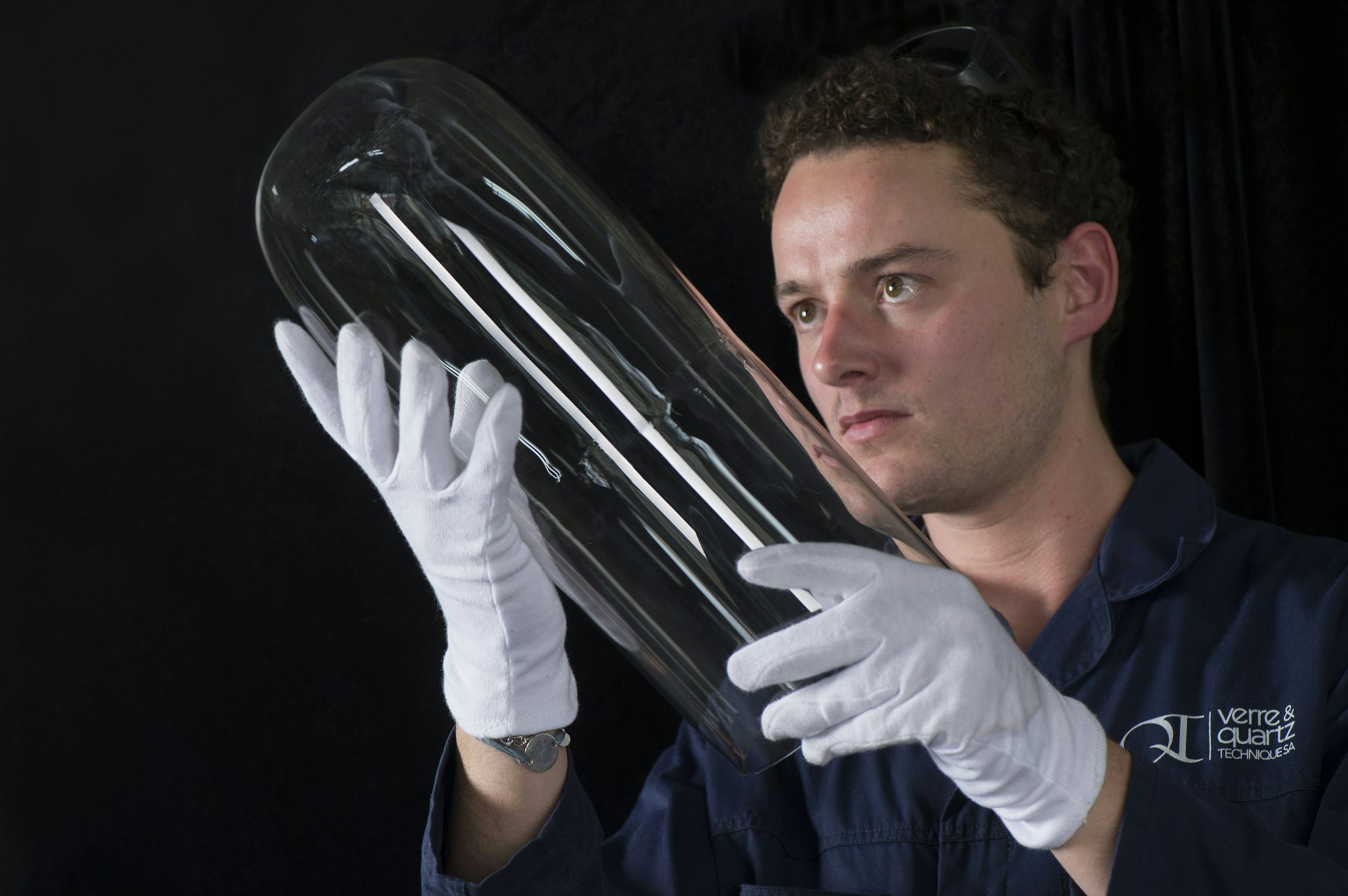 Horologist looking carefully at the just molded glass case of Ulysse Nardin&#039;s UFO timepiece.