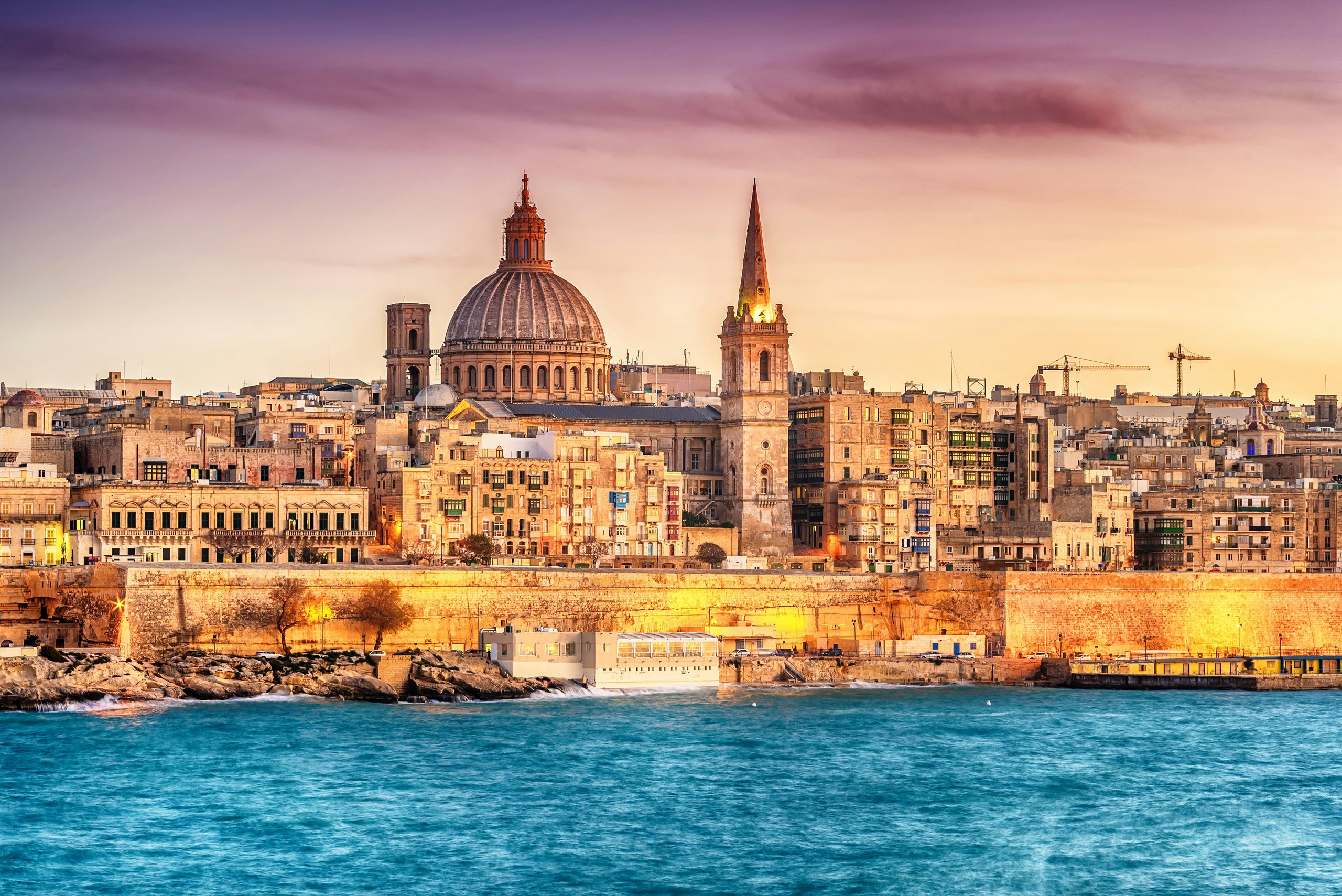 Historic Valletta skyline at sunset, with the iconic St. Paul's Cathedral dome, as viewed from a yacht.