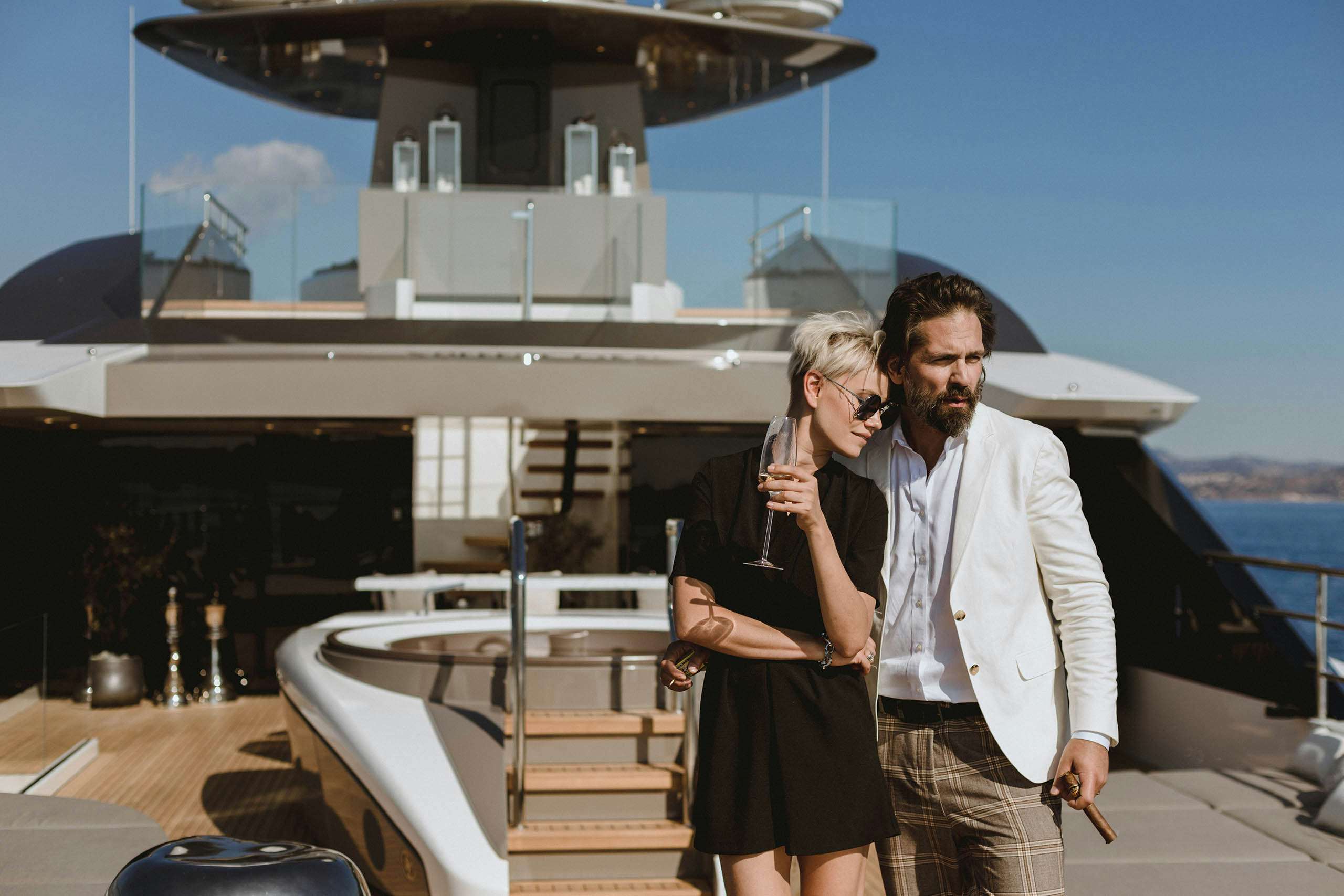 Couple enjoying a cigar and glass of champagne on a yacht deck