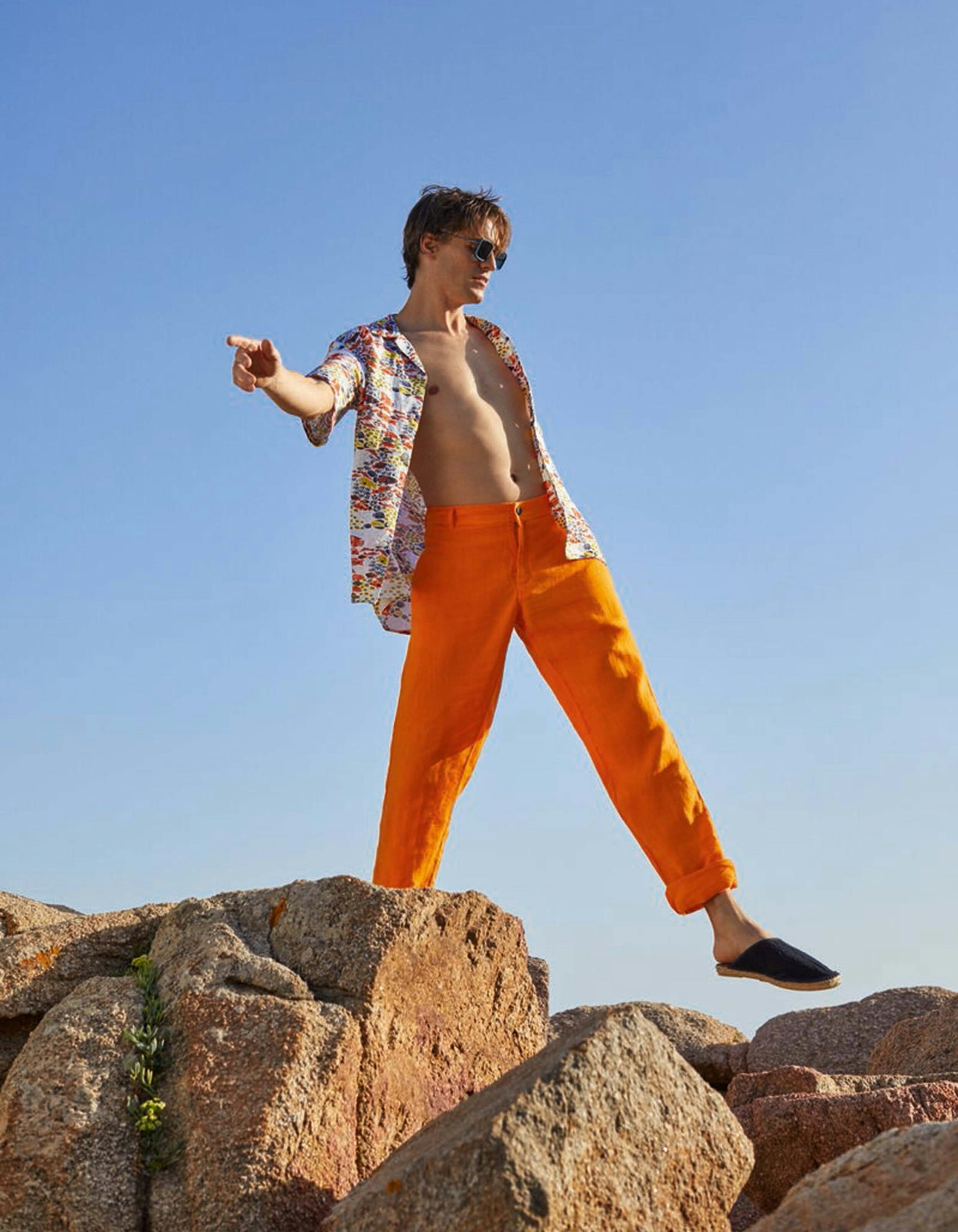 Linen Trousers &amp; Bowling Shirt bright orange pants and open sprinted shirt on a tall guy posing on a rock