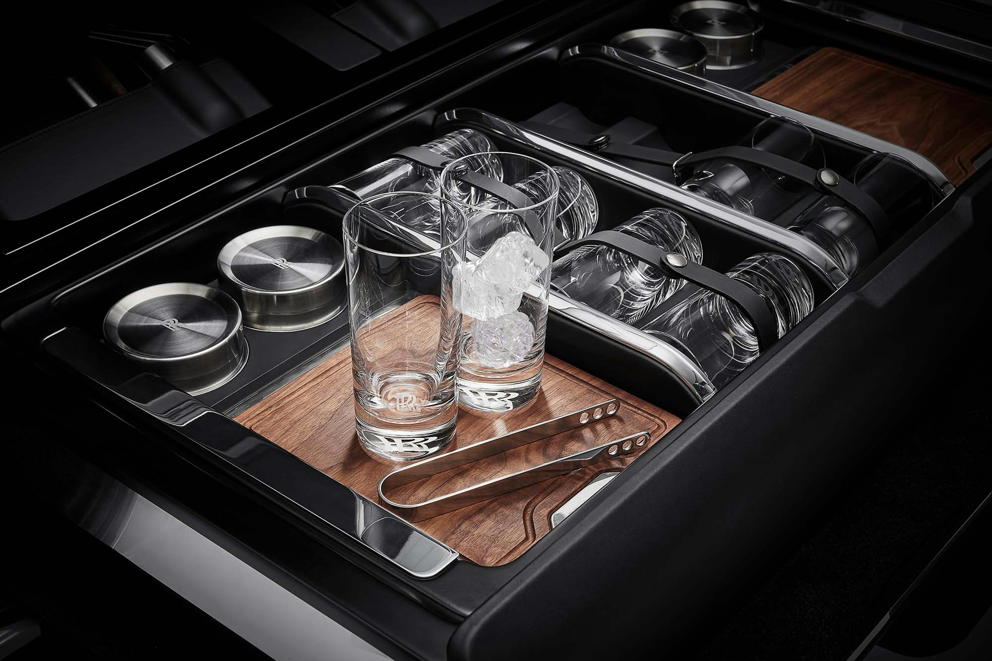 Rolls-Royce Culinan interior luxurious with two glasses, tongs and ice cubes at bar inside the car