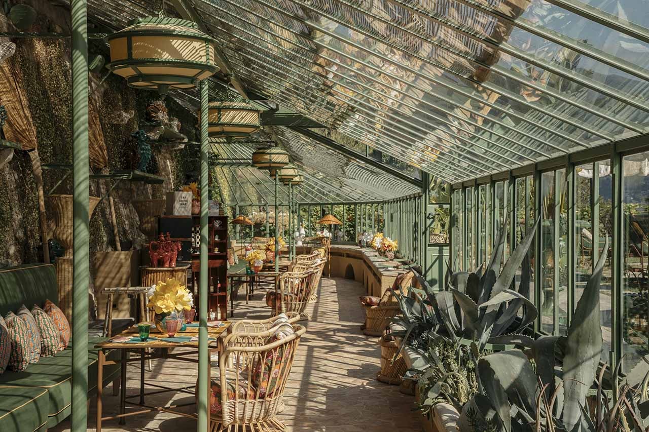 A restaurant inside an old greenhouse with green wrought iron details