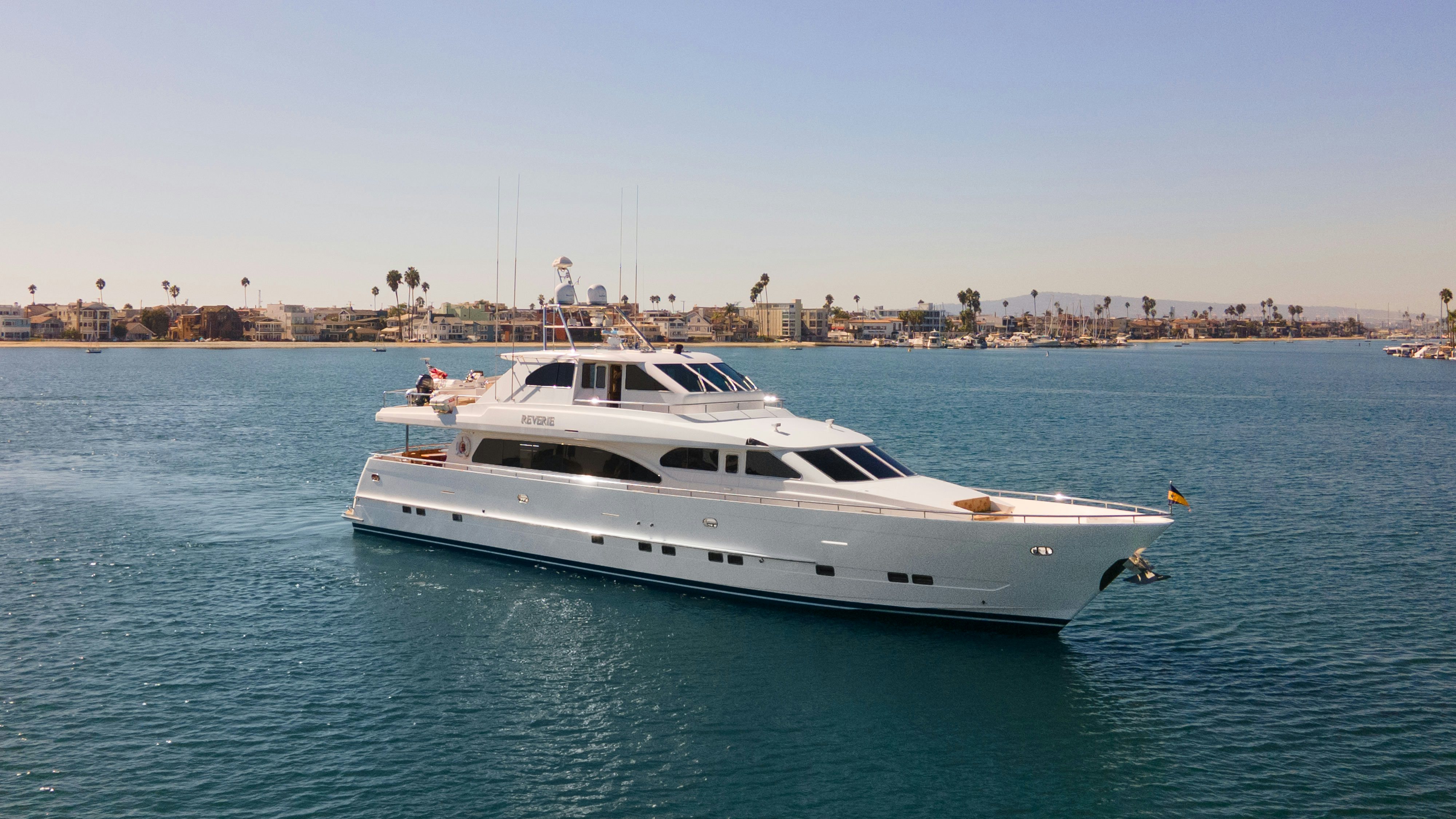 Reverie yacht anchored in a bay in front of a desert scene