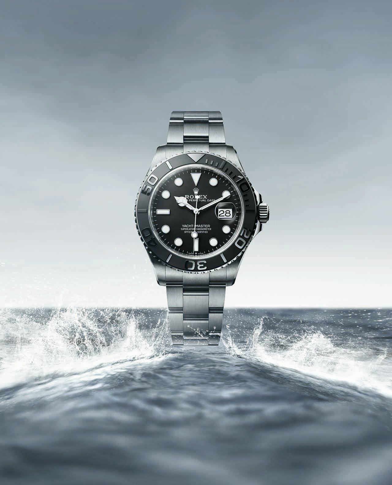 Top down view of a black and silver watch face in front of the sea