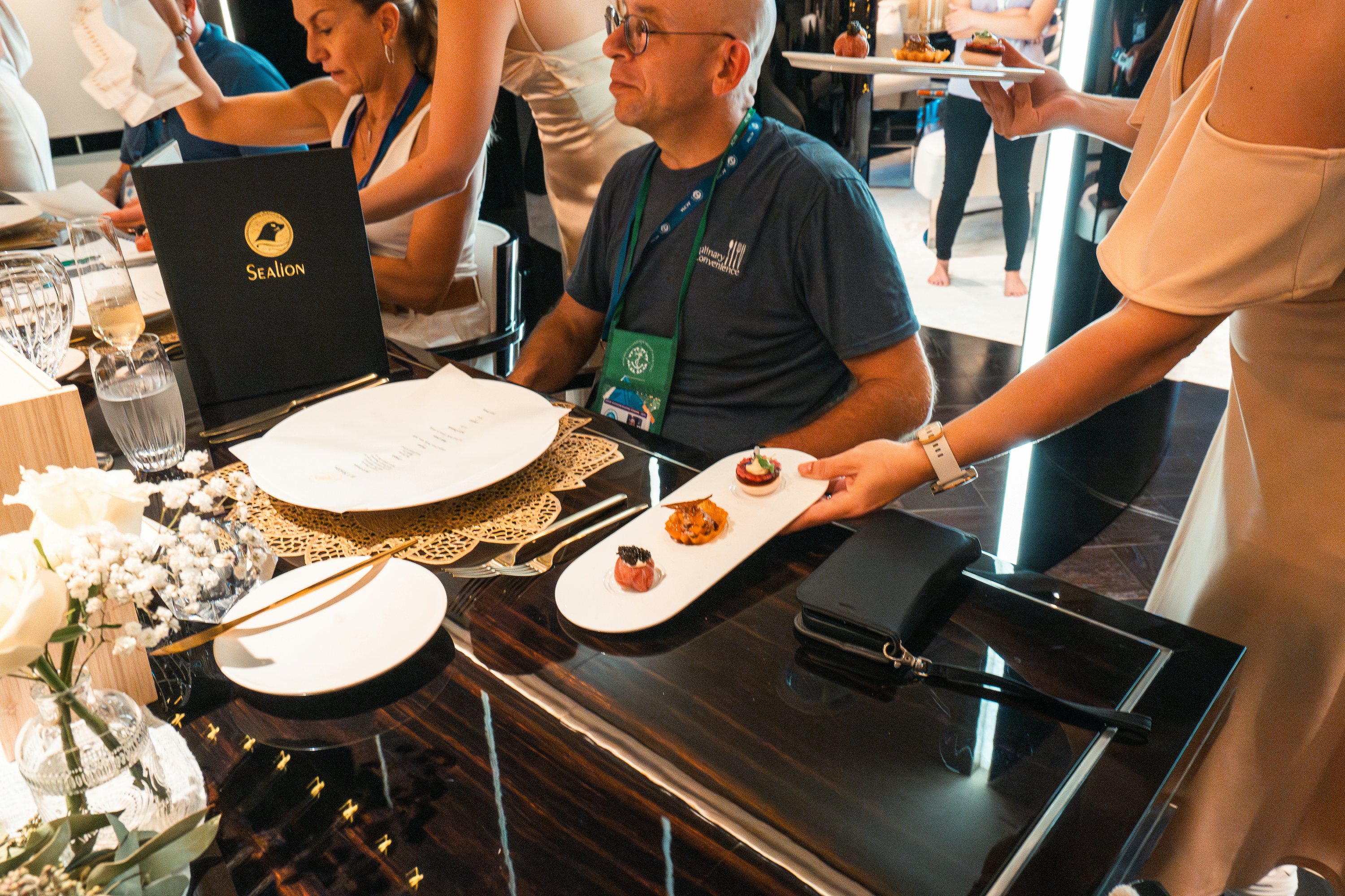 Motor yacht SEALION dining salon during Antigua concours de chef 2024 with judges at the table and dishes being served