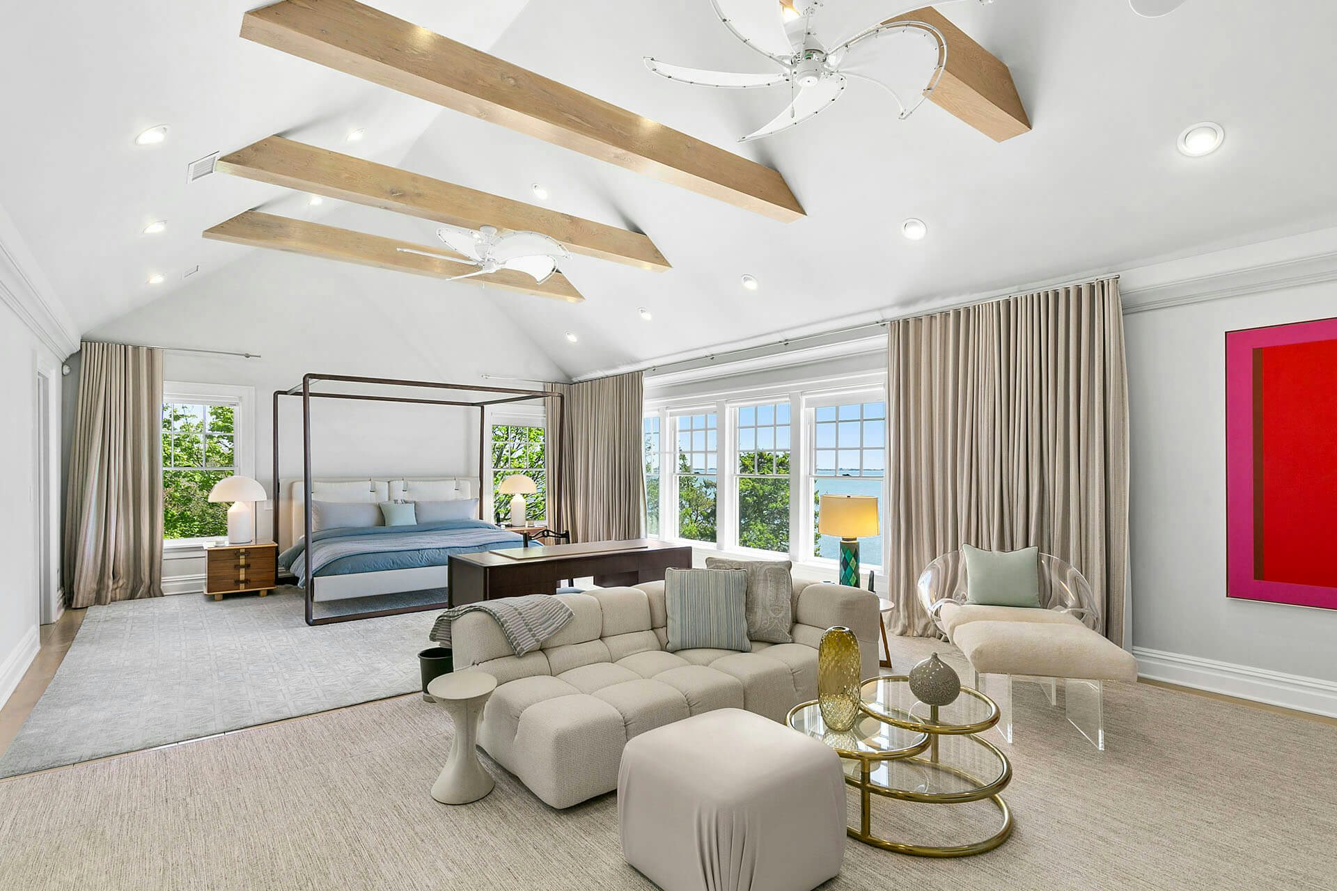 Luxurious master stateroom with a canopy king bed, seating area and ocean views