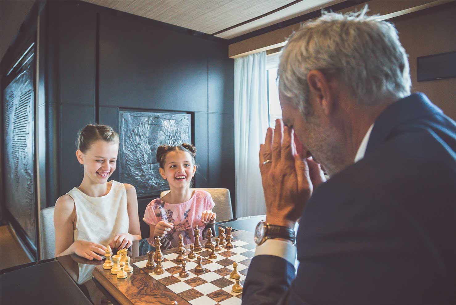 Family playing chess aboard SUERTE