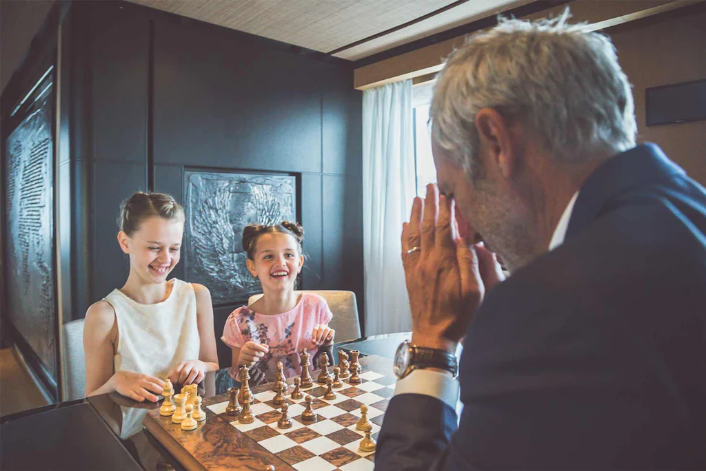 Family playing chess aboard SUERTE