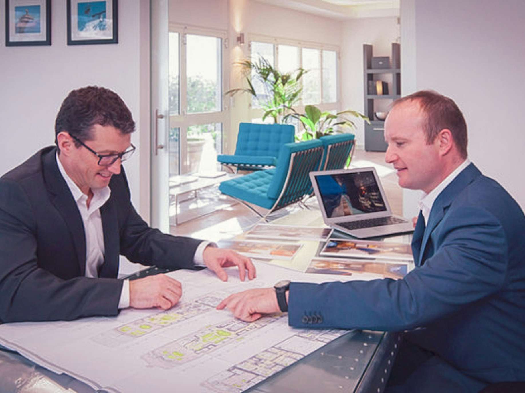 Yacht manager and client looking at yacht designs on desk