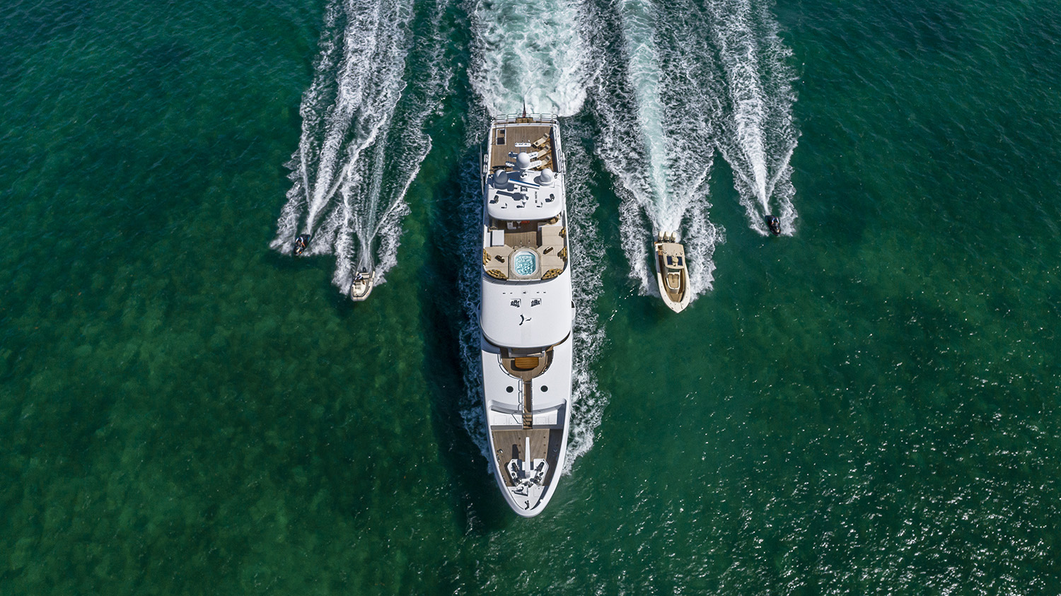 SilverLining yacht with her tenders cruising in greenish waters