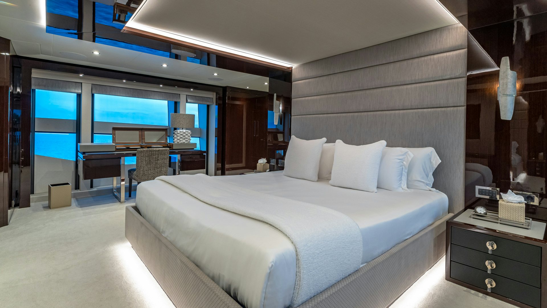 "The master bedroom on the Sunseeker 40 yacht showcases a large, comfortable bed with elegant decor, offering serene ocean views through large windows.