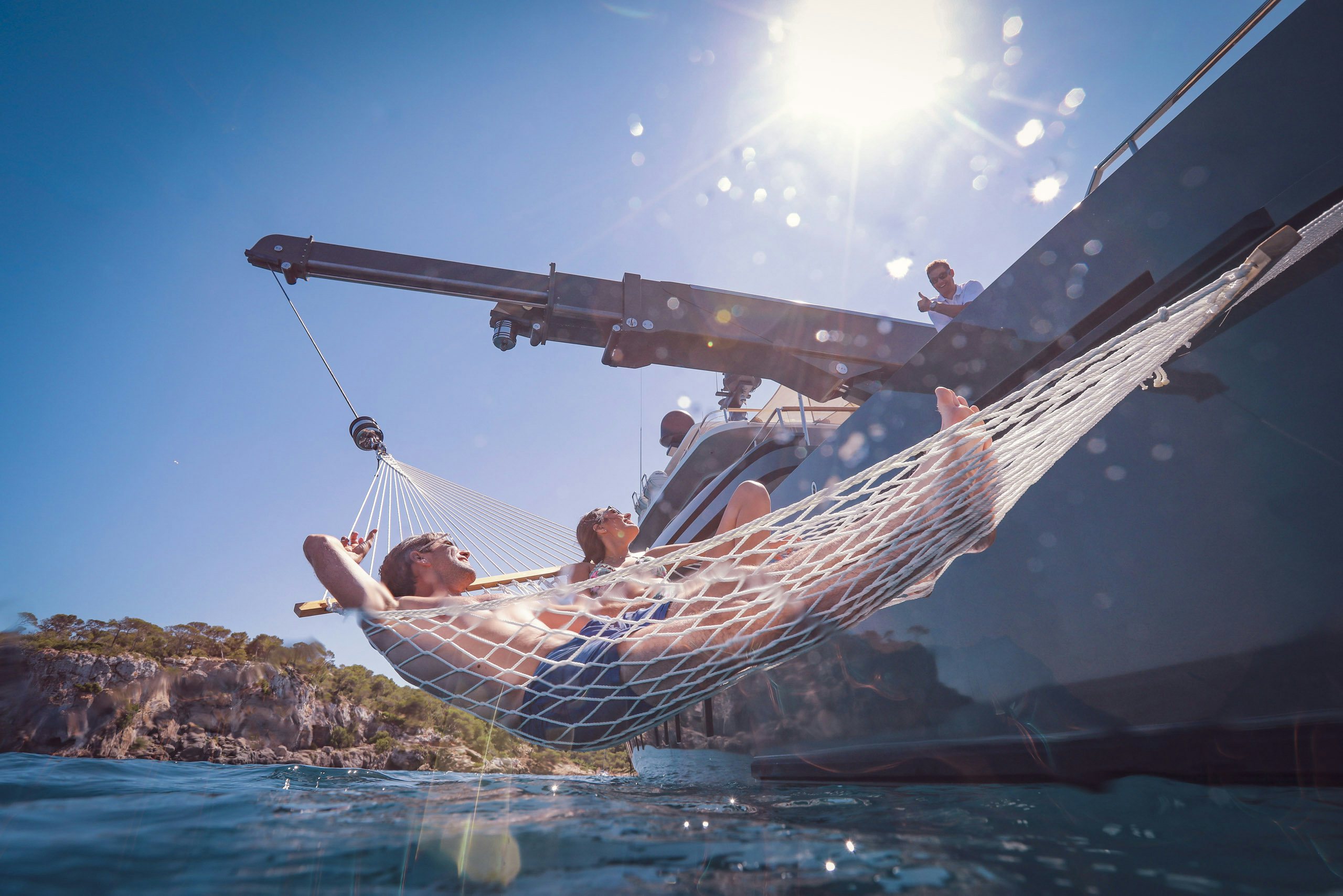 M/Y MokaCopyright © www.yacht-shot.comStuart Pearce Couple longing on hammock hanging to the side of charter yacht