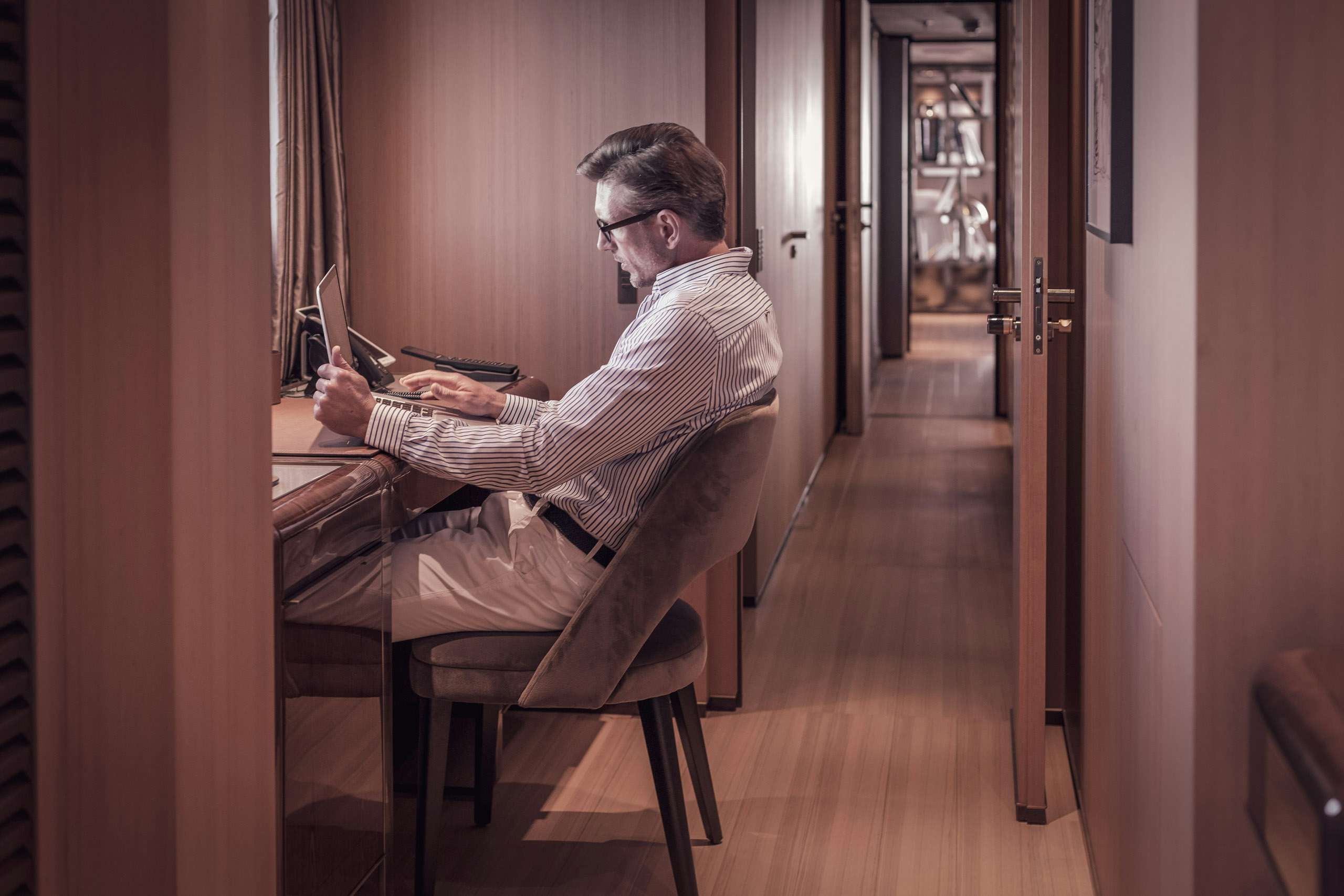 Yacht owner using computer at office on board his yacht