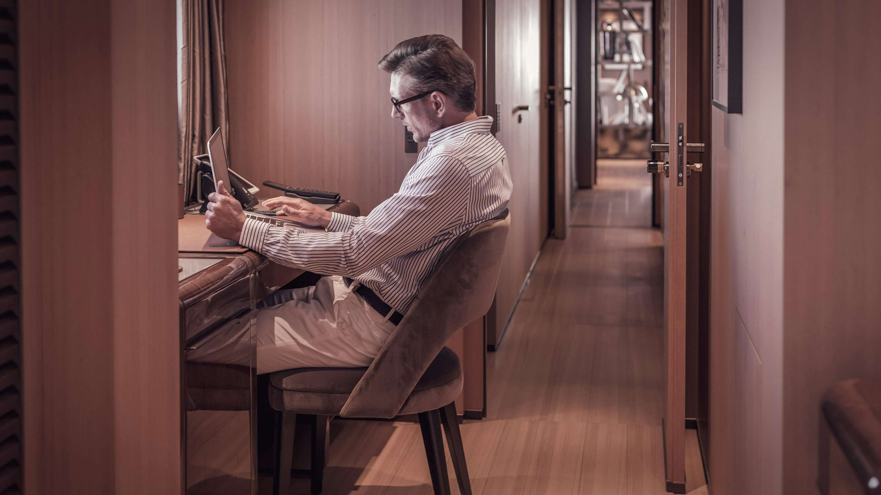 Yacht owner using computer at office on board his yacht