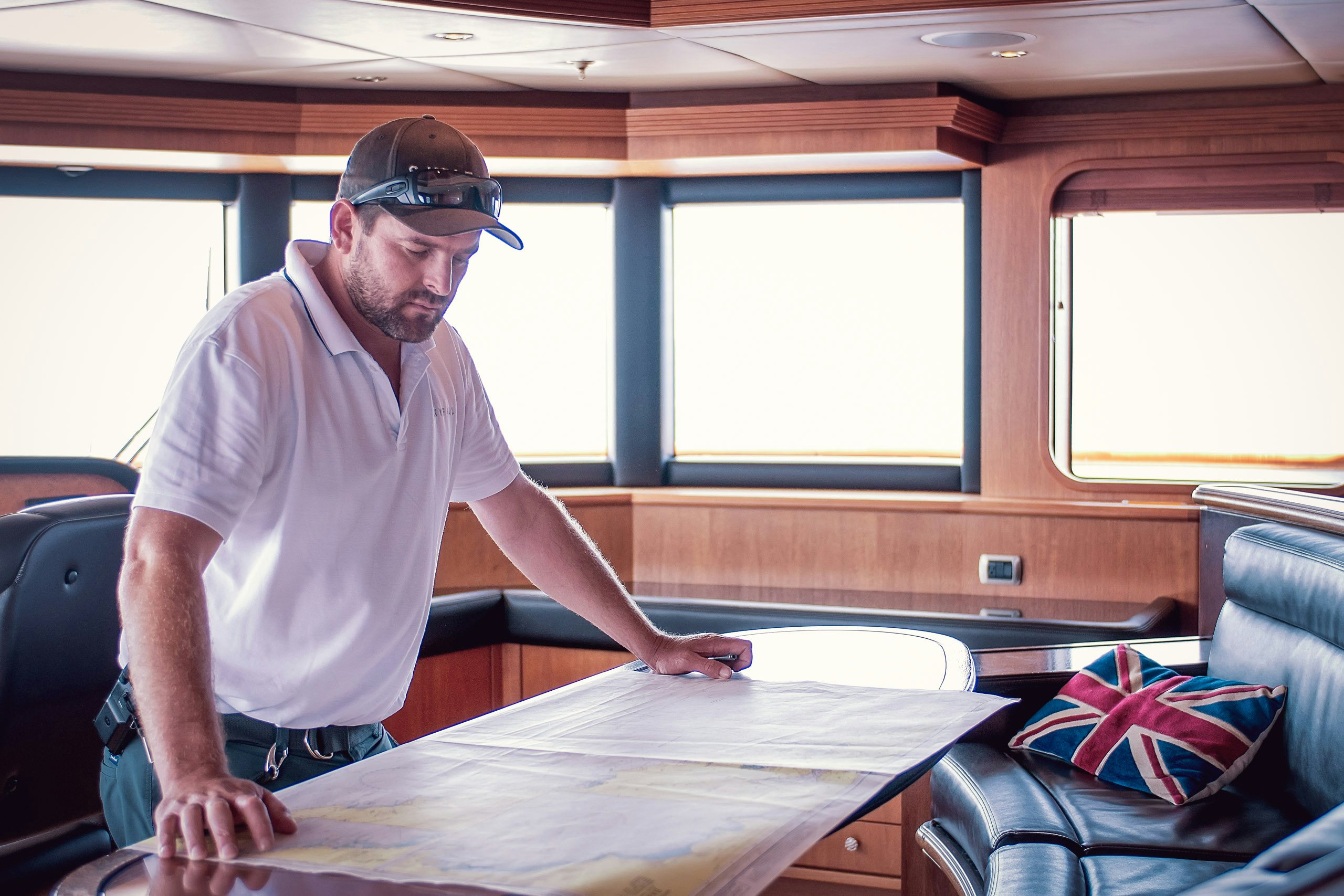Yacht_Management-Protecting_Your_Asset Senior crew inspecting map at wheel house