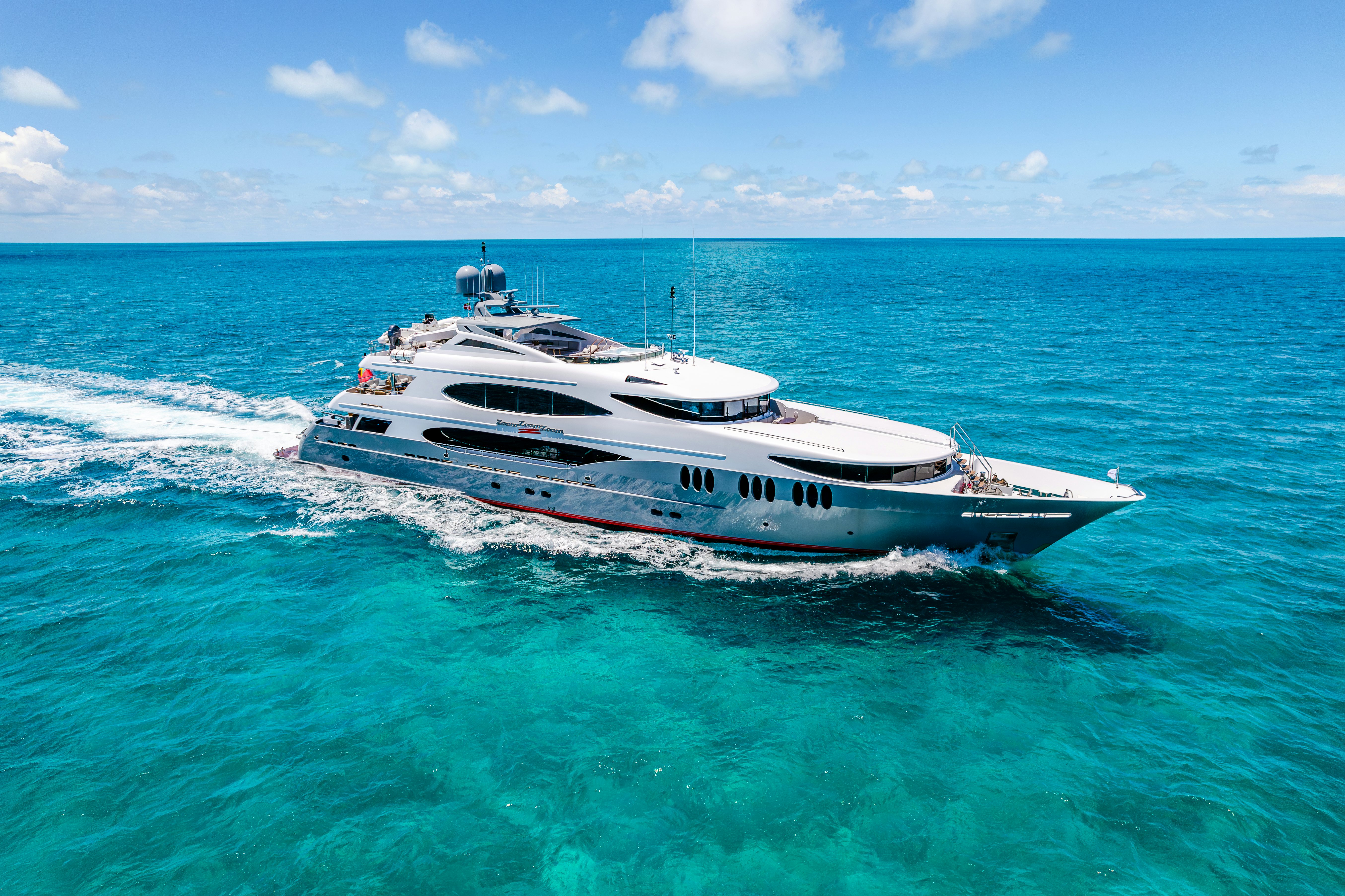 ZOOM ZOOM ZOOM yacht cruising in the cerulean blue ocean in front of a blue sky
