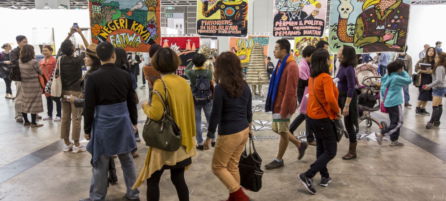 A group of people walking through an underground art space at Art Basel Hong Kong.