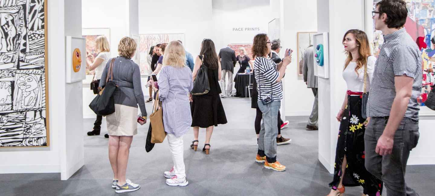 Visitors engaged in viewing and capturing the vibrant artwork on display at Art Basel Miami 2024.