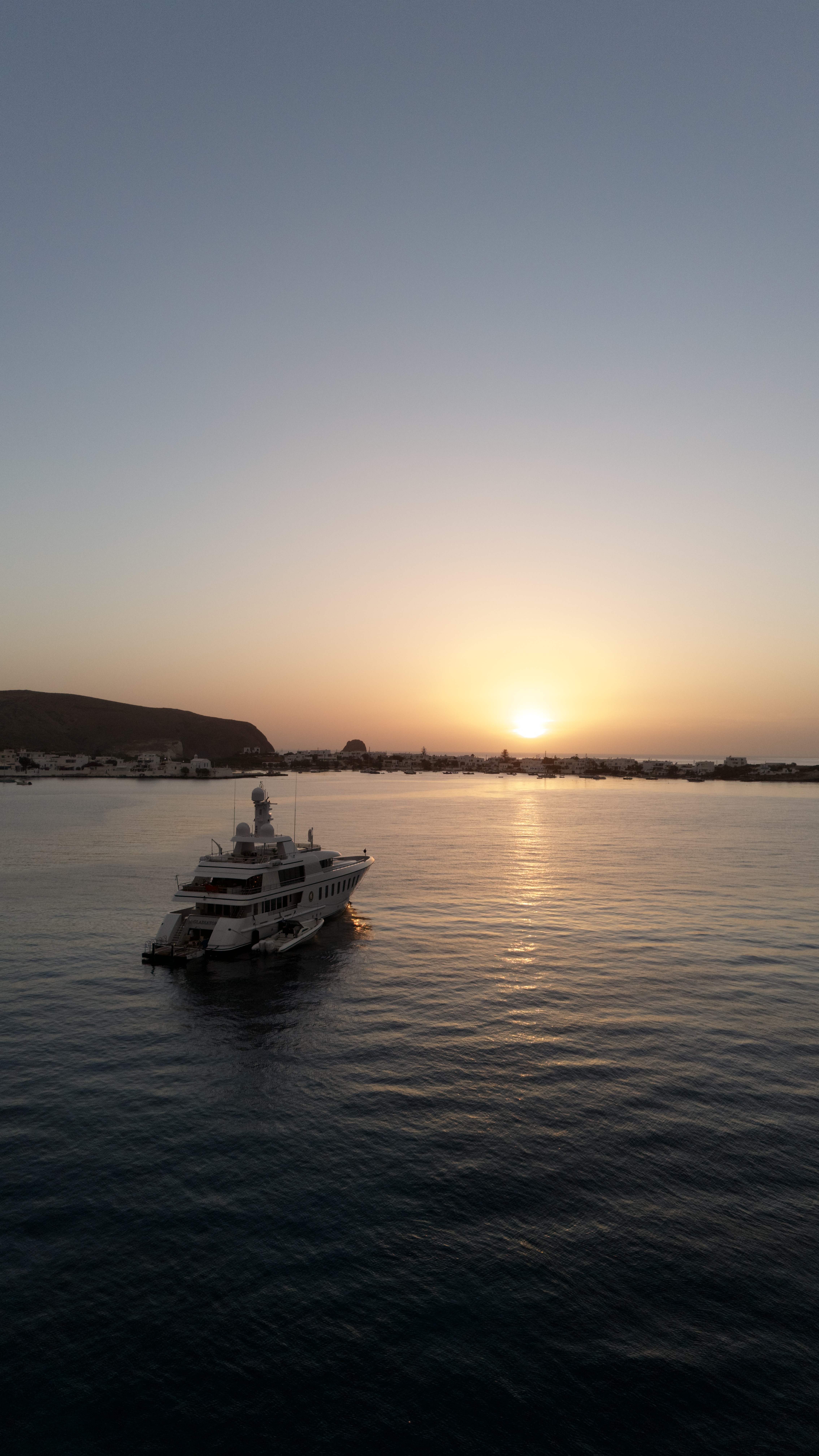 Motor yacht Gladiator facing the setting sun over the ocean