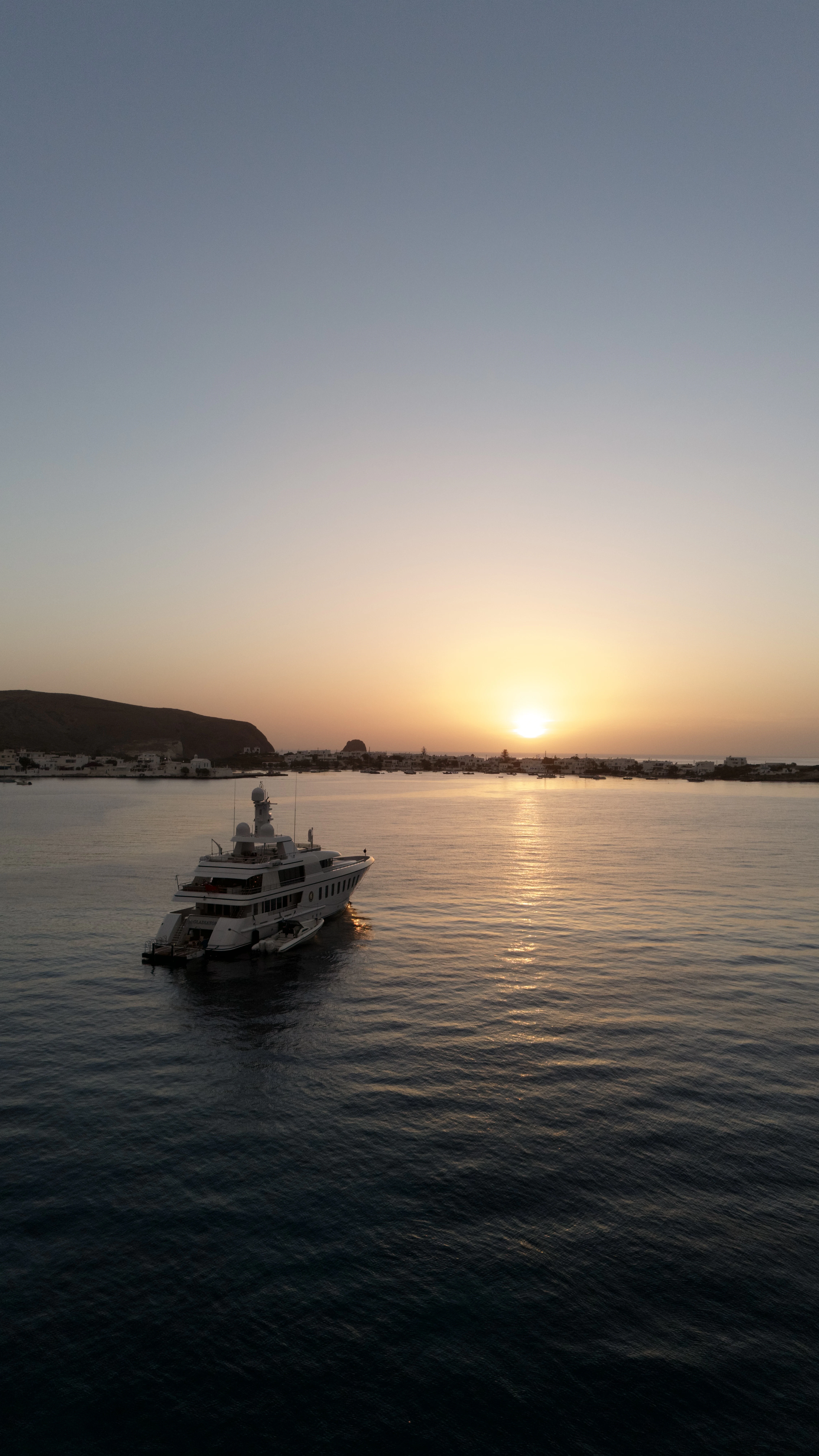 Motor yacht Gladiator facing the setting sun over the ocean