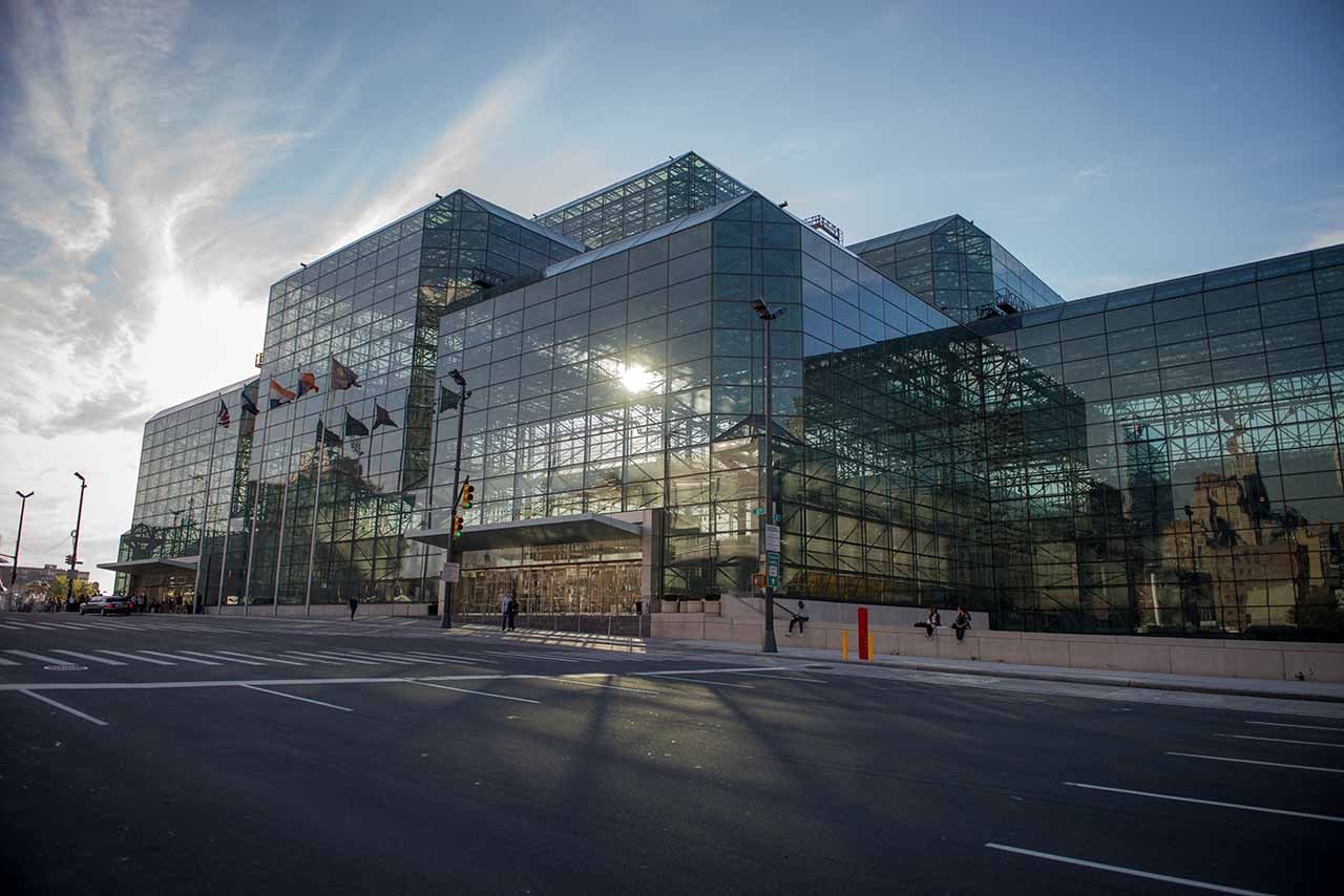The exterior of a glass building with sunlight streaming from behind