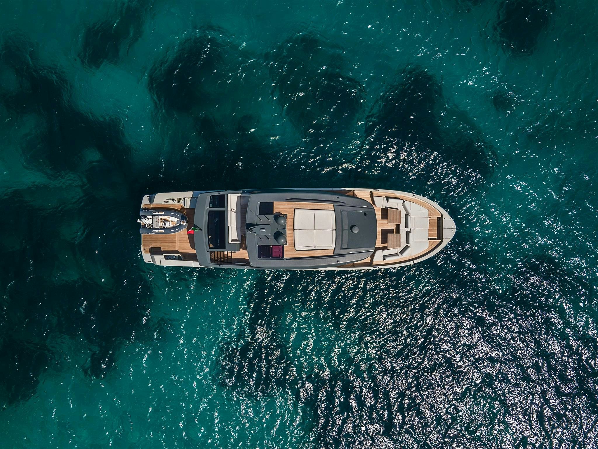 Bluegame 78 MIRAMAR superyacht anchored in turquoise waters, showcasing foredeck lounge and sleek exterior design
