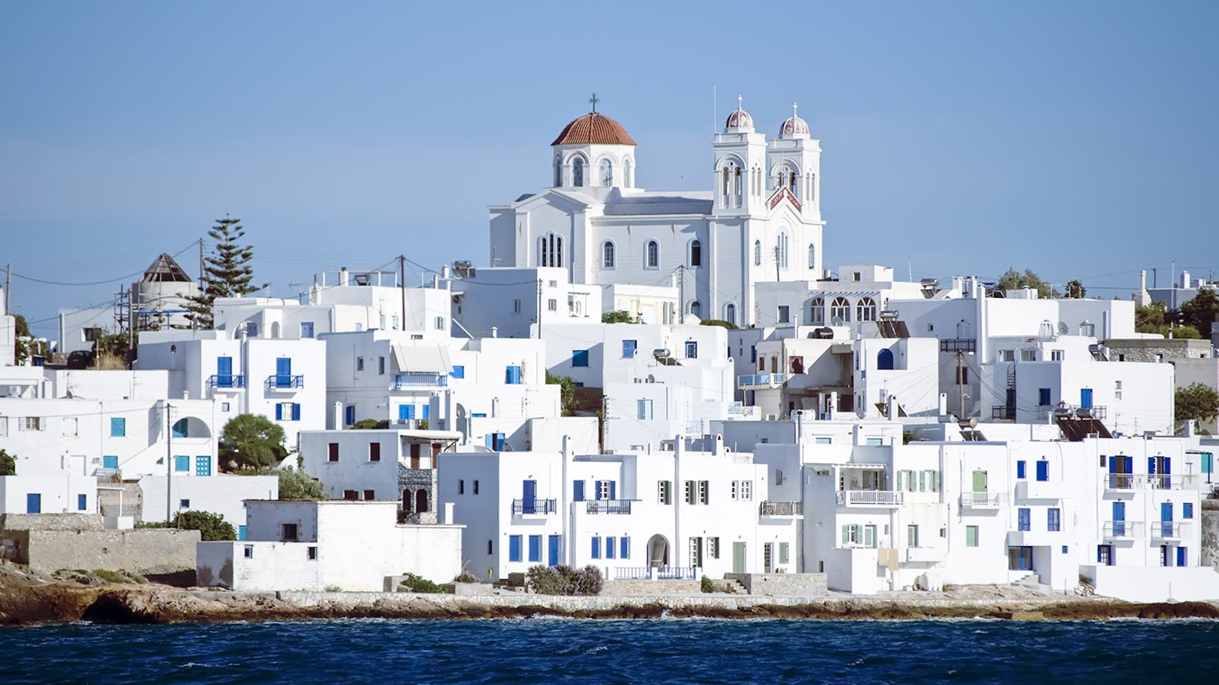 Traditional white-washed Greek village by the sea, perfect for a cultural stop on your Greek yacht charter.