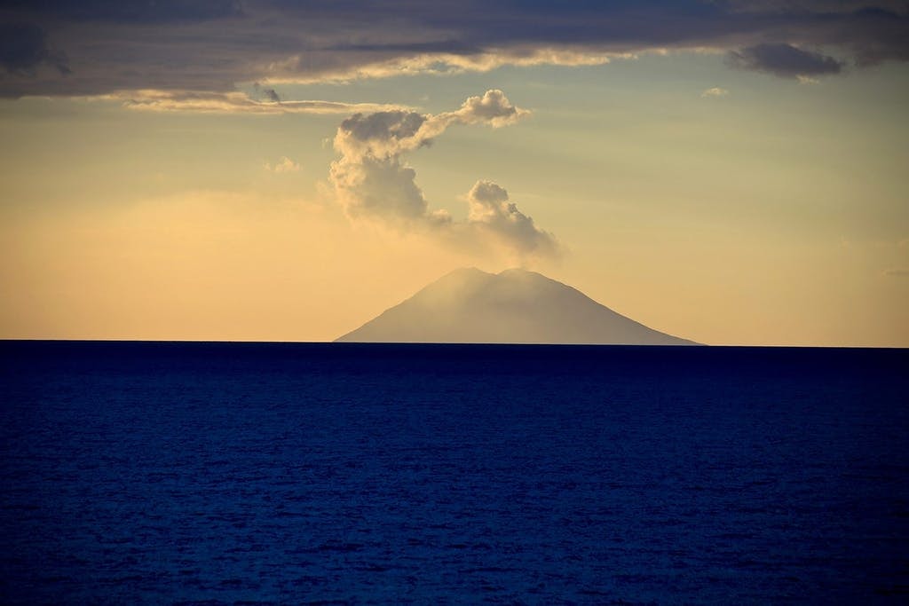scenic yellow sunset and volcano of Stromboli Calabria Tyrrhenian Sea Italy from yacht
