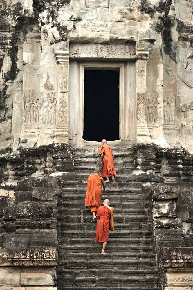 Monks climbing the steps of Angkor Wat